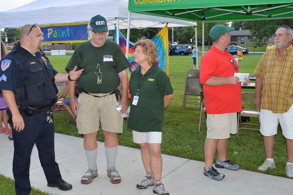 A Villa Park Police Officer talks with members of the Community Emergency Response Team (CERT) at a National Night Out event at the Iowa Community Center, Aug. 2.